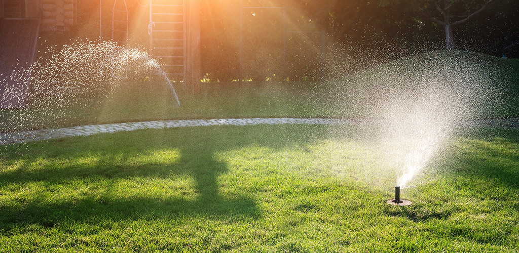 Sprinkler watering a green residential lawn in Birmingham Alabama during summer